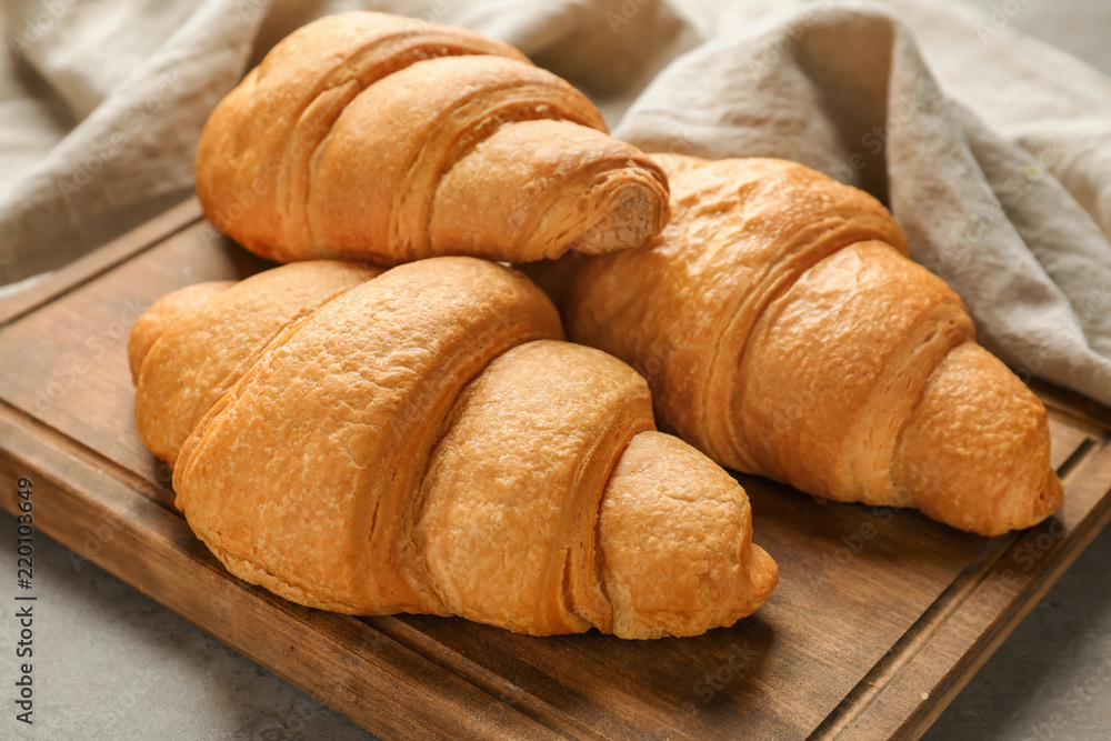 Tasty croissants on wooden board