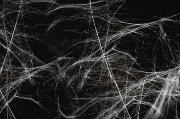 halloween, decoration and horror concept - artificial spider web over black background