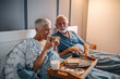 © bernardbodo - Older man and woman eating in bed