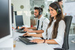 © Bojan - Portrait of call center worker woman accompanied by her team. Smiling customer support operators at work.