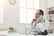 © Prostock-studio - Serious doctor talking on phone with his patient