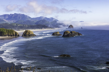 Wall Mural - Haystack Rock with fog behind it as seen from Ecola State Park