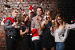 © Vadym - Christmas party, holiday, fun. Happy people celebrating New Year together. Company of friends in Santa caps dancing drinking champagne