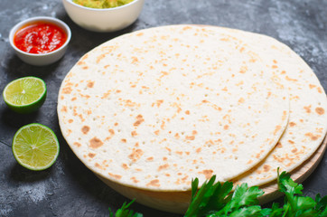 Wall Mural - Plain Tortillas with Tomato Salsa, Guacamole and Fresh Parsley on Dark Background, Wheat Tortillas, Mexican Food