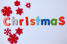 Christmas Card With Word Christmas And Red Snowflakes On White Background. Colorful Letters.