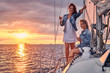 © Fxquadro - Female friends relaxing on the yacht with glasses of wine in the hands, during sunset on the high seas.