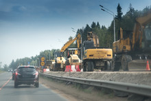 A Black Suv Car On The Road With Concrete White And Red Blocks From One Side And Safety Rail Or Barrier From Other Side. Part Of The Highway Is Under Construction