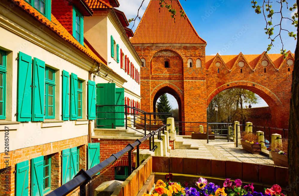 Toruń, ulica na starym mieście z wieżą zamku krzyżackiego - obrazy, fototapety, plakaty 