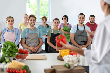 Group of people and female chef at cooking classes