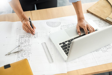 Wall Mural - Person's engineer Hand Drawing Plan On Blue Print with architect equipment, Architects working at the table.