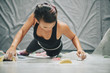 Young Asian woman enjoying bouldering in indoor climbing gym