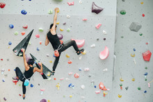 Couple Practicing Rock Climbing On Artificial Wall Indoors