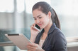 © Mckyartstudio - Young female using her smartphone with tablet while waiting for her flight.