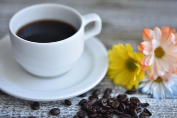 cup of coffee and beans on wooden table