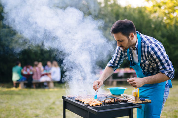 Wall Mural - Handsome man preparing barbecue