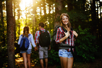 Wall Mural - beautiful woman and friends hiking in forest