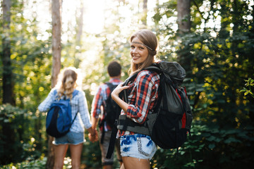 Wall Mural - beautiful woman and friends hiking in forest