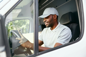 Courier. Delivery Man Reading Addresses Sitting In Delivery Van