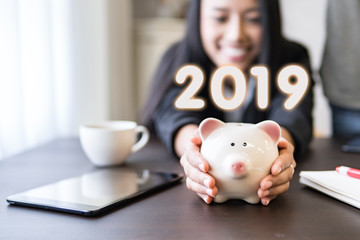 Successful business in 2019.Start new year business goal.Money saving piggy bank for deposit salary and profit income,hands holding piggy bank.