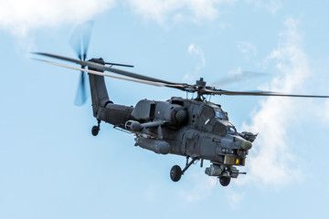 Wall Mural - Military helicopter in the sky on a combat mission with weapons.