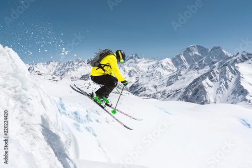 Fototapety Narciarstwo  narciarz-w-pelnym-wyposazeniu-sportowym-wskakuje-w-przepasc-ze-szczytu-lodowca-przeciwko