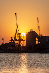  Port with cranes at sunset. 