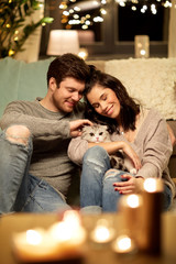 Poster - pets, hygge and people concept - happy couple with cat at home