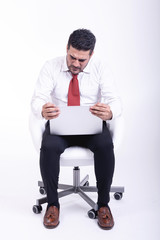 Businessman sitting on white chair isolated.