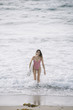 © karrastock - Portrait of a surfer woman on a beach holding a surfboard