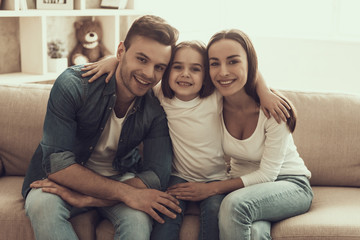 Fototapete - Portrait of Young Happy Family Sitting on Sofa