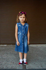 Wall Mural - Girl is 4-5 years, adorable, sweet and shy. On the girl's head are funny pink sunglasses.