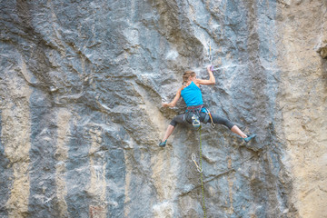 The climber is training to climb the rock.