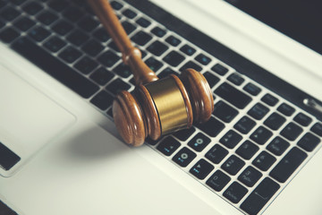 Wooden judge gavel on keyboard laptop computer