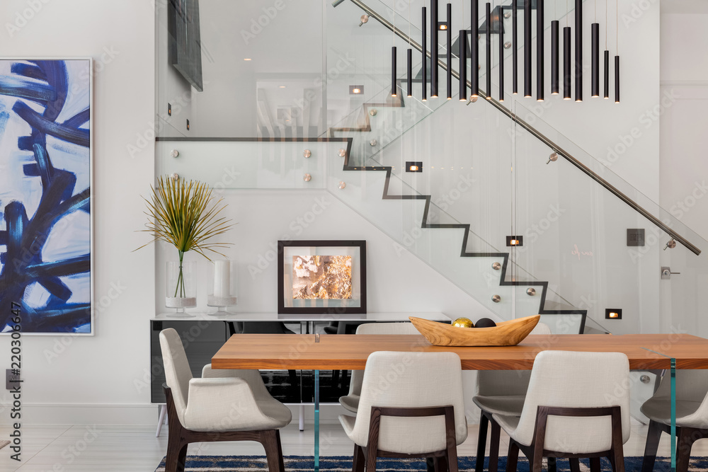 modern open plan dining room with wooden table and glass stairs Stock ...