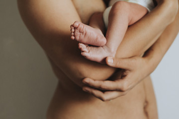 Wall Mural - naked mother holding her infant baby