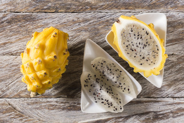 Wall Mural - yellow pitahaya dragon fruit on wooden background