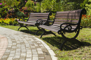 two rustic chairs next to the path in a beautiful parcel