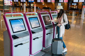 asian female using self-service to check in.