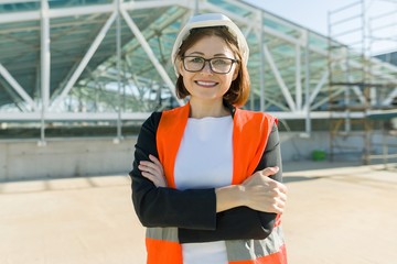 Portrait of mature architect woman at a construction site. Building, development, teamwork and people concept