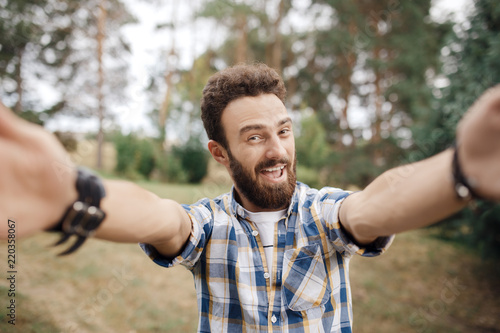 Fotografie, Obraz Excited young hipster man make selfie in the park at the sunset.