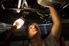 Male Mechanic Examining A Car