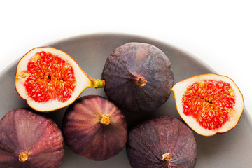 Fresh figs on grey plate. Fruit with half isolated on white.