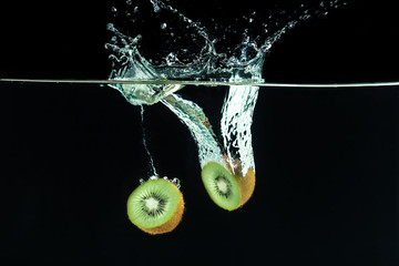 Wall Mural - Splashing kiwi fruit on the water