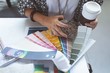 © Wavebreak Media - Female executive checking color swatch on drafting table in