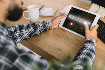 Wall Mural - cropped shot of developer using tablet with search app at workplace