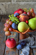 Autumn still life for thanksgiving with autumn fruits and berries on wooden background - grapes, apples, plums, viburnum, dogwood. Raw food. Copy space
