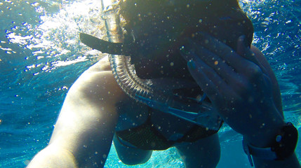 Girl swims near coral in red sea.