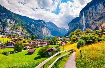 Wall Mural - sunny summer view of great waterfall in lauterbrunnen village