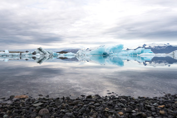 Wall Mural - Jökulsárlón glacier lagoon with refelctions of a ice rock in the water an the glacier in the background of the jökulsarlon