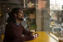 Man Looking Through Window In Cafe